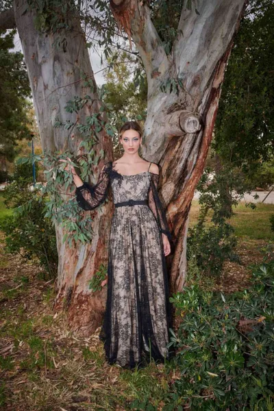 Estelle Dress Black by JULYTWO - Fine Chantilly lace with a plisse soleil skirt, off-the-shoulder top, wide sleeves, 3D lace rose brooch, and leather belt.