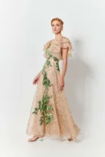 JULYTWO Leilani-kjole i pailletter med blomsterblonde med en A-silhuet med et elegant ærme og blomsterbroderi.